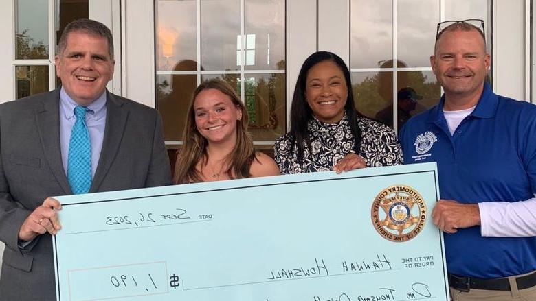 Montgomery County Sheriff's Office Chief Deputy Adam Berry, 县专员贾米拉·温德说, 学生汉娜·豪沙尔, and Sheriff Sean Kilkenny with Hannah's scholarship check